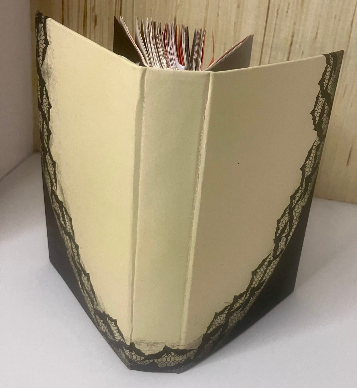 Cream journal cover edged with black lace, showing the handbound pages