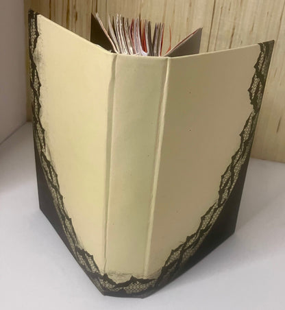 Cream journal cover edged with black lace, showing the handbound pages