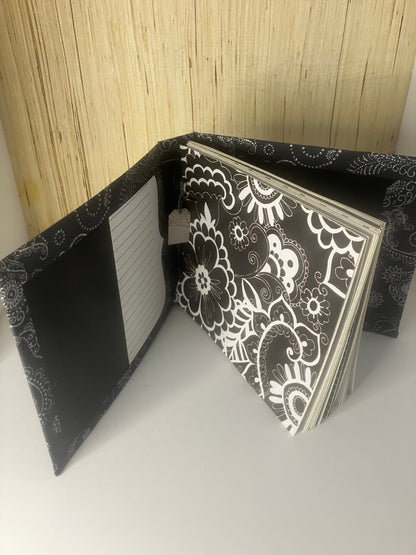 Black and white journal opened to patterned pages and a lined inside cover