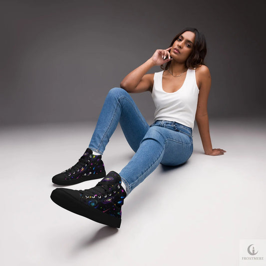 Woman sitting on the floor wearing blue jeans and black sneakers against a gray background